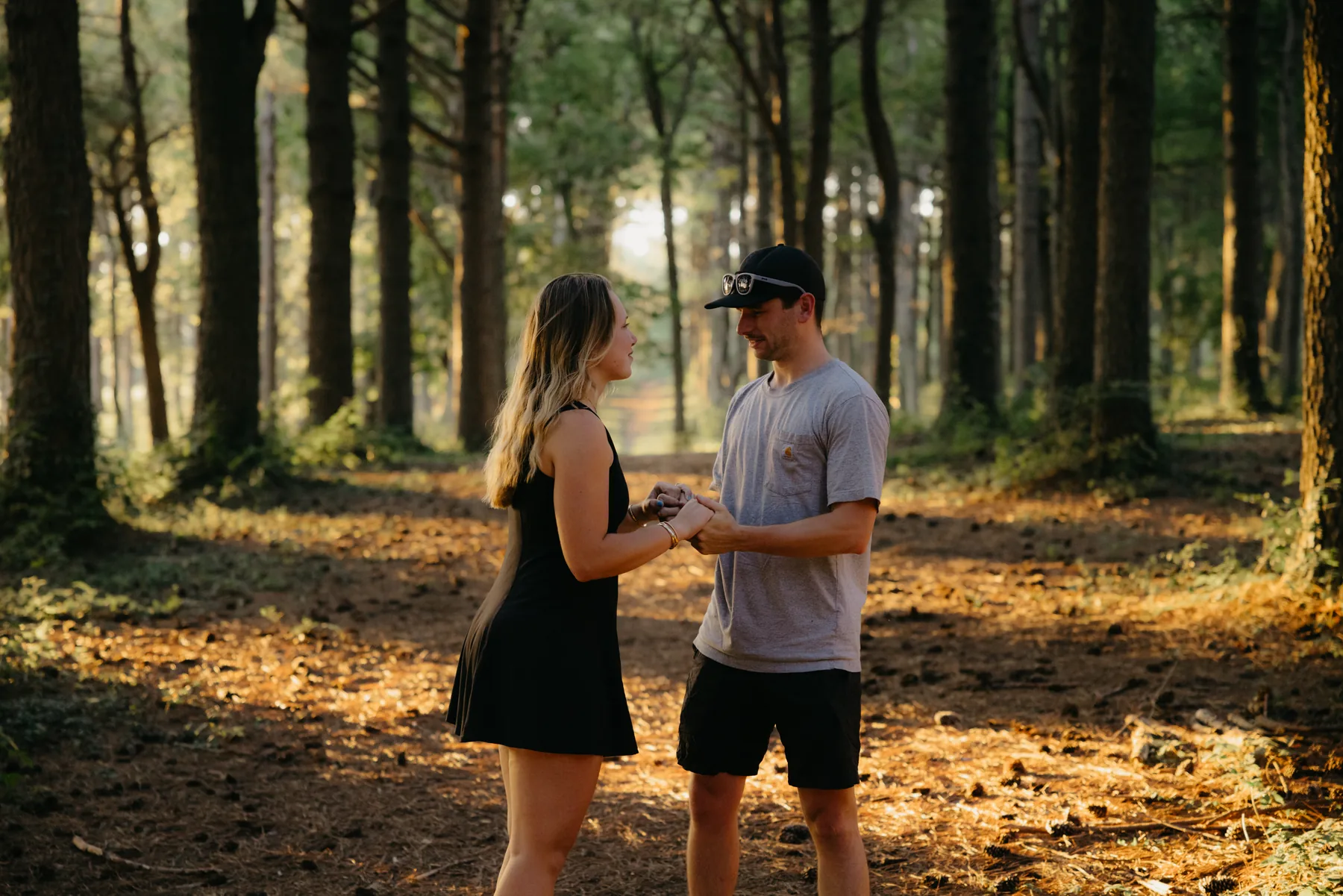 Facing each other on the path, holding hands in the pines