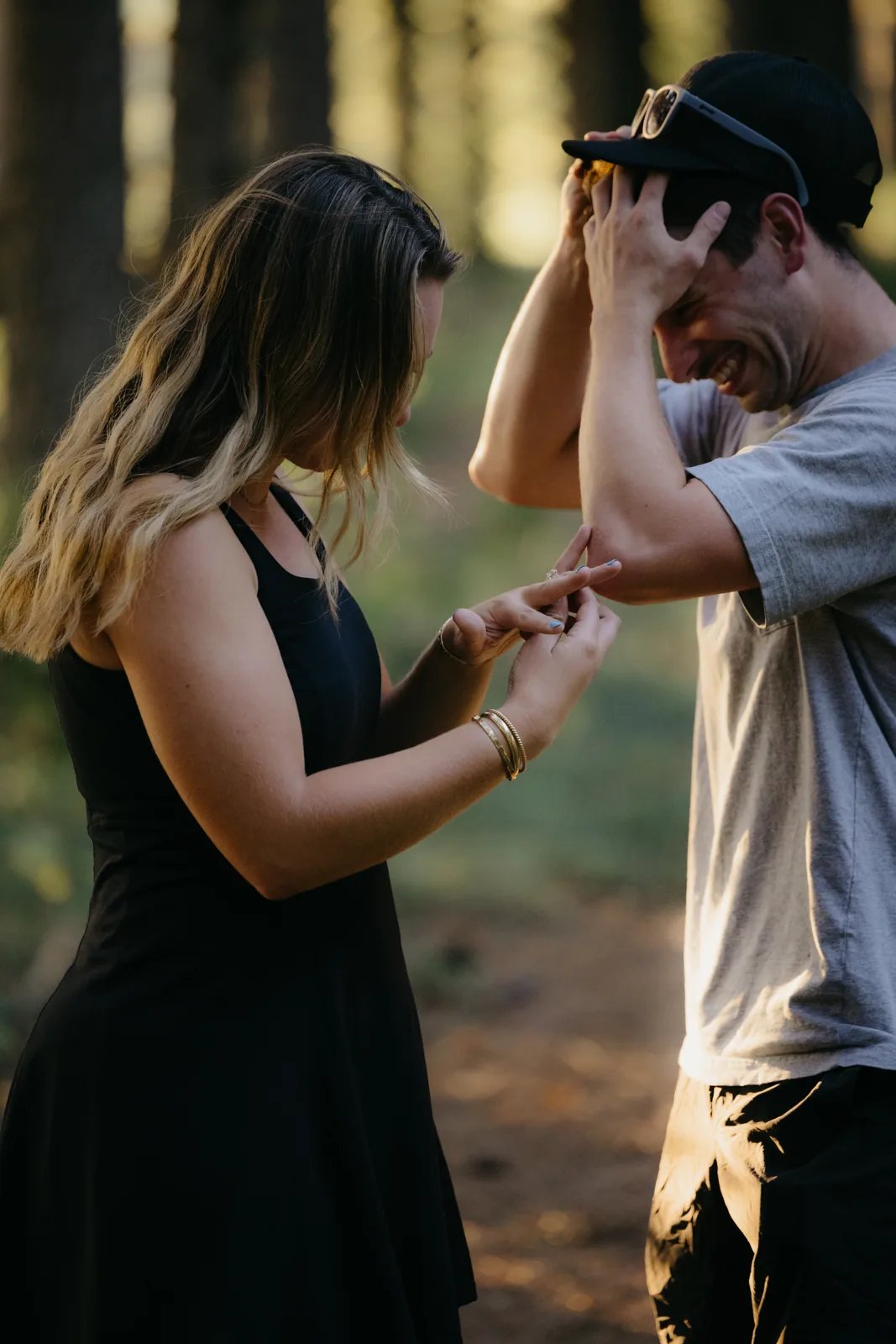 Holding hands, backlit by golden light through the pines