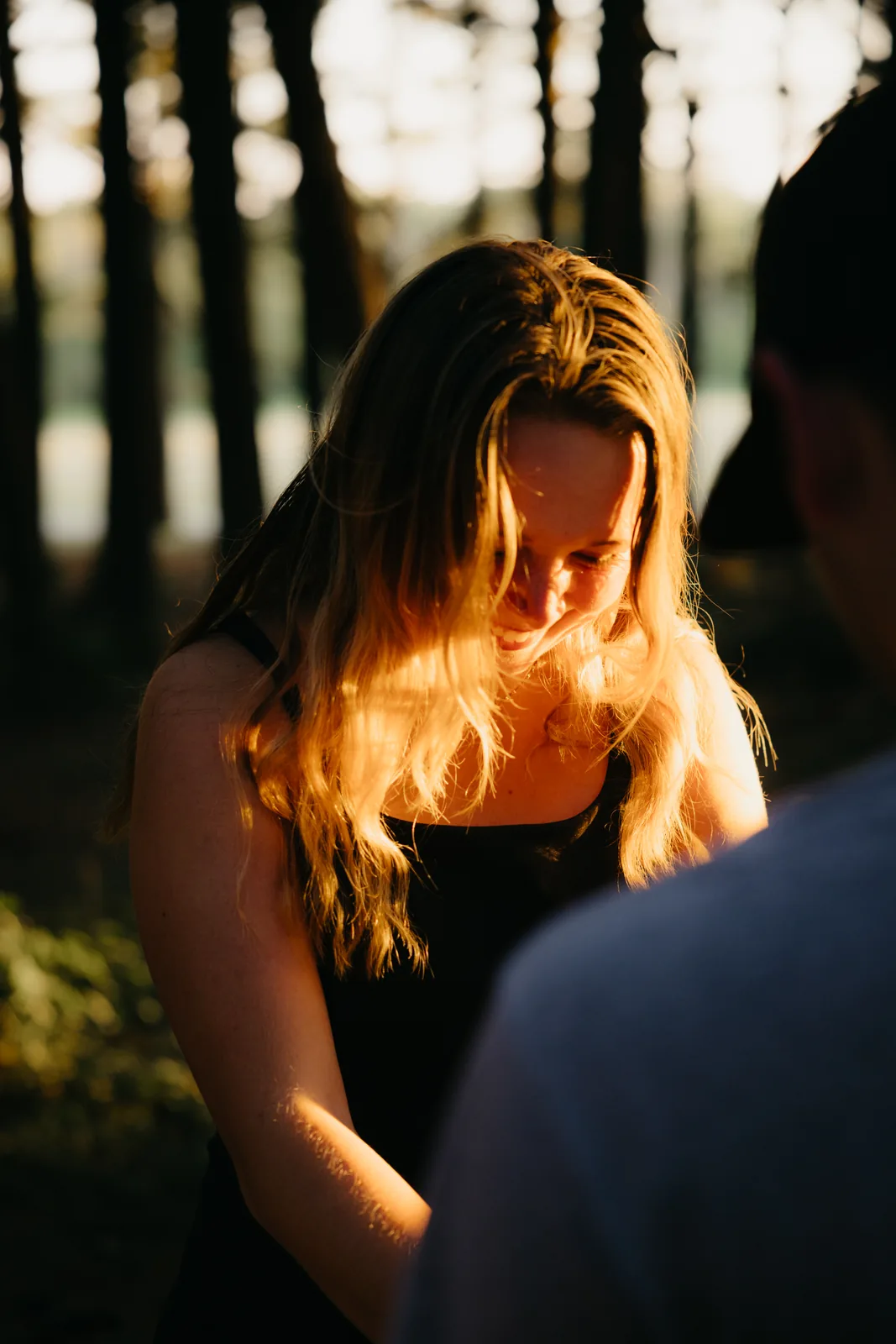 Her looking down, hair lit gold by the setting sun