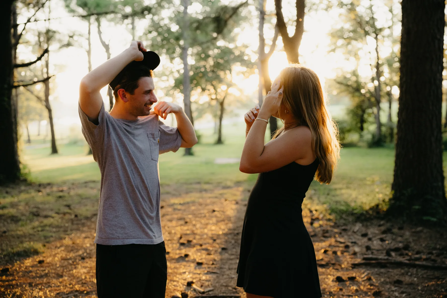 The two of them laughing on a forest path, arms up mid-celebration